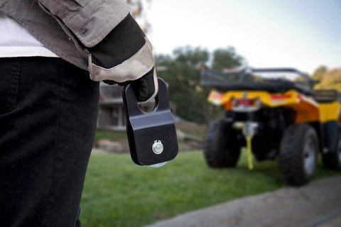 8000 Lb Snatch Block For Off Road Winch Systems That Doubles Pull Power And Eases Angled Pulls Reduces Winch Heat And Gear Stress Fits Up To Five Sixteenth Inch Wire Rope Heavy Duty Black Powder Coated Brackets in hand near ATV