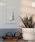 Effortless Install Paddle Dimmer Smart Switch With Matter Ready Wiring And Alexa Support For Smooth Lighting Control mounted on a wall next to a plant.