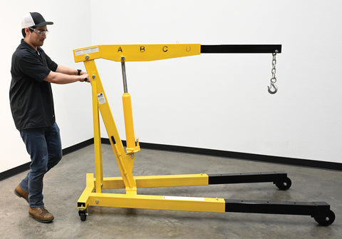 Heavy Duty Steel Engine Hoist With Telescoping Legs And Adjustable Boom Supporting 6000 Lb in use for garage lifting tasks.