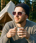 Man wearing Top Shelf Photochromic Safety Glasses Featuring Fast Adapting Lenses Beefy Side Shields Ansi Z87 Approved, holding a mug.