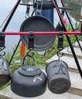 Camping gear hanging on outdoor tripod with Five Piece Large Outdoor Camping Hook Set, S Shaped Movable Strap Hooks for Quick Hanging.