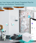 Living room with 2nd Gen Smart Bluetooth Fingerbot Plus Wireless Light Switch Button Pusher, phone showing Tuya app control interface.
