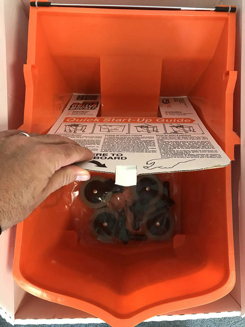 Open top view of RBC-323 Roll A Bucket With 3 Inch Caster Wheels And Brake 6 Gallon Orange Rolling Bucket with instruction manual.
