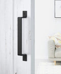Heavy Duty Black 10 Inch Barn Door Handle Set Two Pack Carbon Steel For Sliding Doors Cabinets Closets Drawers And Garages Includes Two Sets Of Different Length Screws For Easy Install installed on a white barn door