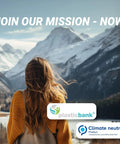 Back view of a woman in a yellow sweater looking at snow-covered mountains, promoting Plastic Bank's climate neutral mission.