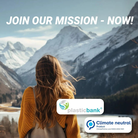 Back view of a woman in a yellow sweater looking at snow-covered mountains, promoting Plastic Bank's climate neutral mission.