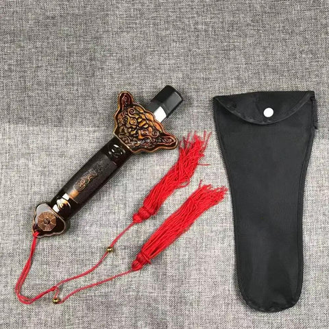 Scalable Tai Chi Training Sword Kit With Storage Pouch, featuring ornate handle detail, pouch alongside red tassels on grey fabric.