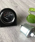 Front view of a 52mm oil pressure gauge with sensor and mounting hardware, black dial, 0–100 PSI.