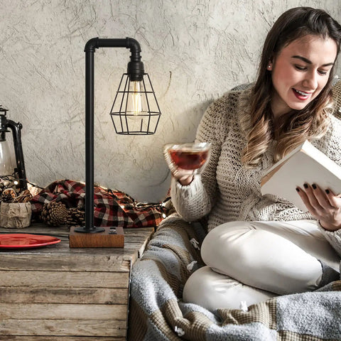 Woman reading next to Industrial Style Touch Control Table Lamp With LED Bulb Included, 3 Way Dimmer, 2 USB Ports And AC Outlet.