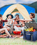Collapsible Soft Cooler Bag With 75 Can Capacity For Beach And Road Trips Flip Top Lid Leakproof Ice Chest Lightweight Portable Cooler On The Go With 5 Layer Insulation And 12 Hour Cold Retention Great For Camping Groceries In Blue in front of people camping with tent and grill