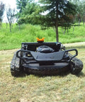 Remote Control Lawn Mower With Tracked Drive For Slopes And Uneven Ground, front view in grassy field