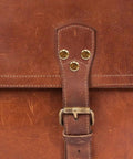 Close-up of heavy duty copper binding screws with golden tone on a leather bag, showcasing sturdy alloy design.