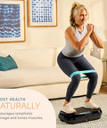 Woman exercising on Waver Mini Vibration Plate For Full Body Toning And Lymphatic Drainage With Remote And Bands in living room