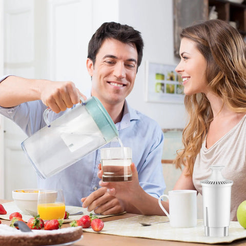 Couple using water filter replacement for Brita pitchers, NSF certified, in kitchen setting, pitcher on table