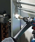 Bosch HBT225 2-1/4 in bi-metal T-slot hole saw on cordless drill drilling into metal panel