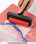 Hand using roller on diamond art canvas from All In One 22 Piece 5D Diamond Painting Tools Kit With Roller Storage Box Tweezers Pens Trays And Glue
