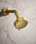 Awaken G90 Multifunction Showerhead With Three Spray Modes mounted on marble wall in brass finish