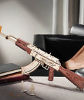 Dope 3D Wooden Puzzle Kit For Adults, DIY Rubber Band Gun Build, decorative AK-47 wood model on a desk with books and lamp