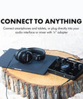 Dope Over Ear Studio Headphones With Closed Back Design, resting on a tablet, connecting to an audio interface on a wood table.