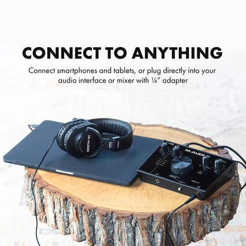 Dope Over Ear Studio Headphones With Closed Back Design, resting on a tablet, connecting to an audio interface on a wood table.