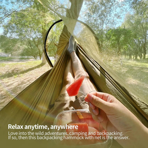 Person relaxing in Lightweight One Person Hammock With Mosquito Net Easy Setup Portable Camping Hammock in olive 70D nylon.