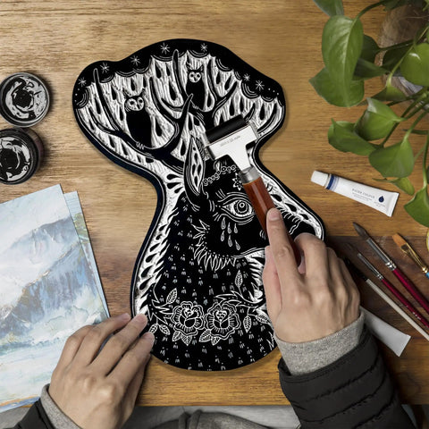 Hands using Soft Rubber Brayer Roller With Wooden Handle For Printmaking And Inking Blocks on carved surface with intricate design.