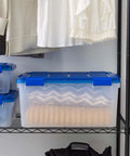 A 60-Quart Clear Airtight Storage Tote with Secure Latching Lid, stacked on a shelf, holding blankets in a closet.