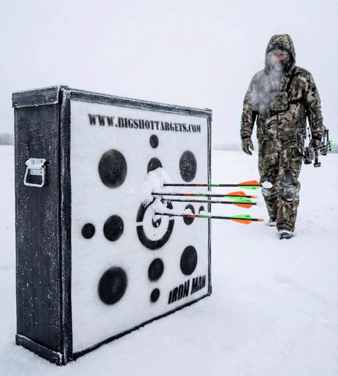 Iron Man 30 Inch Archery Target For Personal Range, 475 FPS Rated beside hunter in snow, arrows embedded in target.