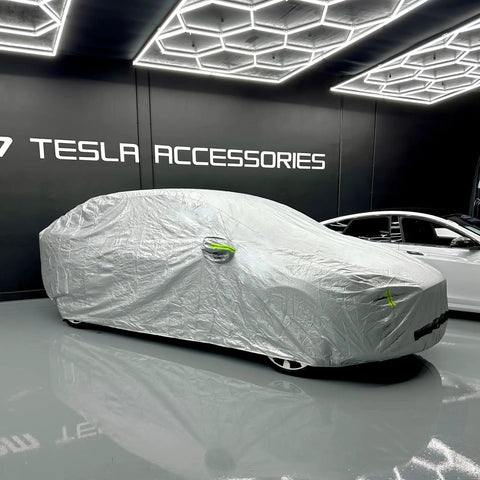 Badass Heavy Duty Weatherproof Car Cover For Tesla Model X Silver Microfiber Weave fitted snugly over the vehicle in a showroom.