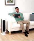 Man in living room with AeraMax 100 Air Purifier with True HEPA Filter and Four Stage Purification for mold odors dust smoke allergens and germs