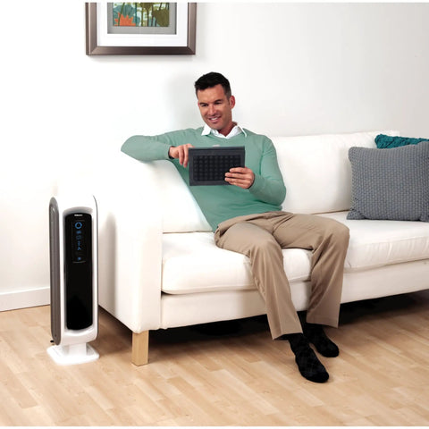 Man in living room with AeraMax 100 Air Purifier with True HEPA Filter and Four Stage Purification for mold odors dust smoke allergens and germs