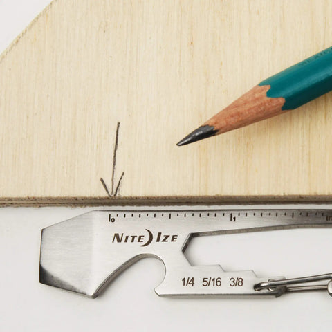 Silver Carabiner Key Clip One And Eleven Sixteenth Inch with measurement scale next to a pencil on wooden surface