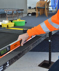 A hand using the No Nonsense 48 Inch Digital Box Level on a flat surface for precise leveling in a workspace setting.