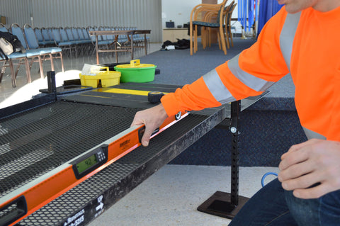 A hand using the No Nonsense 48 Inch Digital Box Level on a flat surface for precise leveling in a workspace setting.