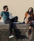 Two people sitting with Rock Solid Inline Skate Wheels 76mm 24mm High Density Urethane For A Smooth Ride Indoors And Outdoors Durable Replacement Wheels.