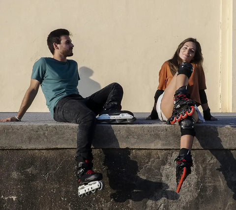 Two people sitting with Rock Solid Inline Skate Wheels 76mm 24mm High Density Urethane For A Smooth Ride Indoors And Outdoors Durable Replacement Wheels.