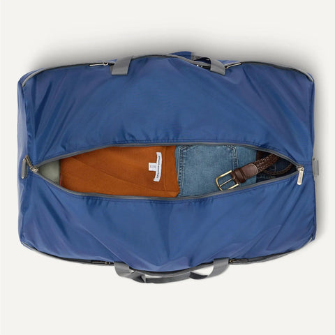 Top view of Extra Large Foldable Nylon Carryall Duffle Bag for Travel and Storage with Zippered Pockets, showing packed contents.