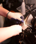 Person sharpening a metal blade using Rock Hard Bench Grinder with Eight Inch Grinding Wheels and a variable speed motor.
