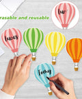 Hands writing on 45 Piece Colorful Hot Air Balloon Cutouts for Bulletin Boards And Classroom Decor, 9 Styles with Easy Glue Dots.