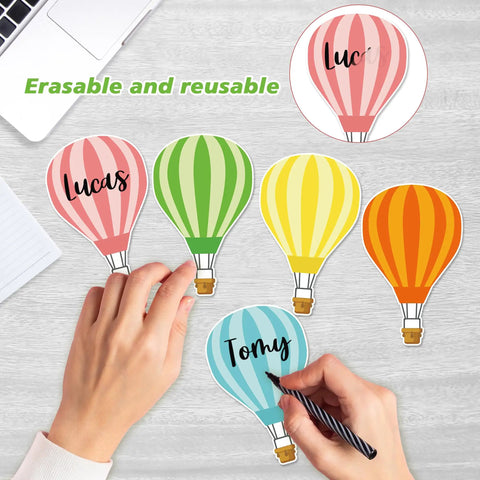 Hands writing on 45 Piece Colorful Hot Air Balloon Cutouts for Bulletin Boards And Classroom Decor, 9 Styles with Easy Glue Dots.