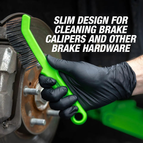 Gloved hand using slim steel wire brush for brake calipers with angled head for tight spots and rust removal on brake rotor