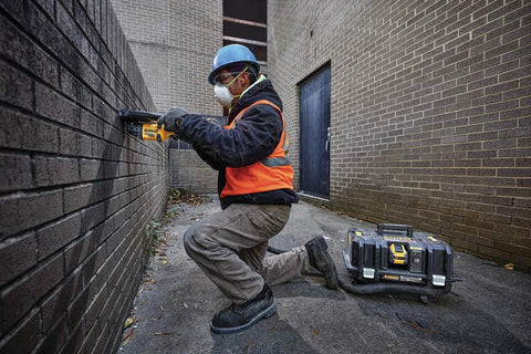 Worker using 60V Max Brushless Cordless Grinder With Kickback Brake Four And A Half Inch To Six Inch Wheel 9,000 RPM for brick grinding