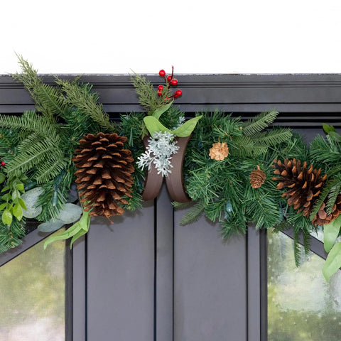 Heavy Duty Adjustable Front Door Garland Hanger With Padded Ends Providing Rock Solid Grip On Jambs From 51 To 81 Inches Holding 20 Lbs Of Decor For Zero Stress Holiday Setup with festive garland on a door.