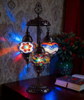 Boho Mosaic Glass Triple Globe Turkish Table Lamp With Handmade Moroccan Lampshade In Purple 21 Inch on table with patterned wall