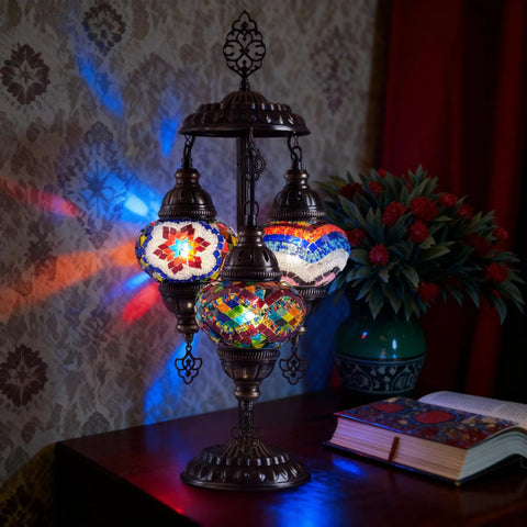 Boho Mosaic Glass Triple Globe Turkish Table Lamp With Handmade Moroccan Lampshade In Purple 21 Inch on table with patterned wall
