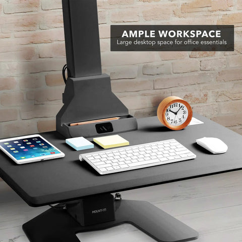Heavy Duty Electric Standing Desk Converter With Monitor Mount And Wide Keyboard Tray sitting on a smooth surface with workspace essentials.