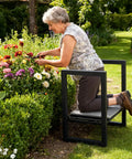 Senior woman using Heavy Duty Garden Kneeler And Seat 500 lb Capacity 2 In 1 Bench For Kneeling And Sitting Anti-Tip in garden