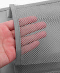 Hand showcasing the mesh pocket detail of the Slick Door Shoe Organizer With Six Deep Mesh Pockets And Heavy Duty Hanging Hooks.