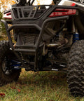 Rear view of Arched Boxed Radius Rods for Polaris RZR Pro XP and Pro XP 4 Off Road Upgrade With High Ground Clearance Beefy Rugged Steel Build Powder Coated Black Finish Easy Install And Durable Performance on a UTV.