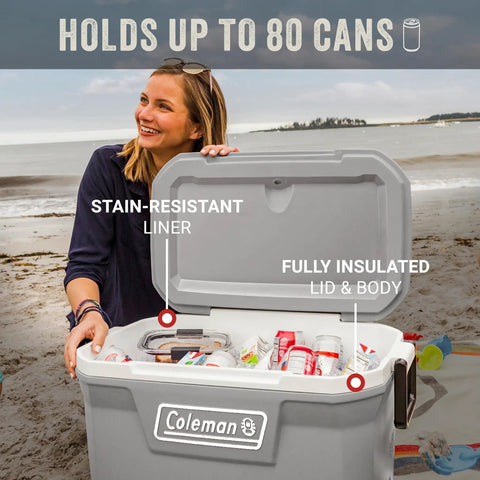 Woman holding open Classic Series Insulated Portable Cooler with Leak Resistant Build on beach, fits up to 80 cans.